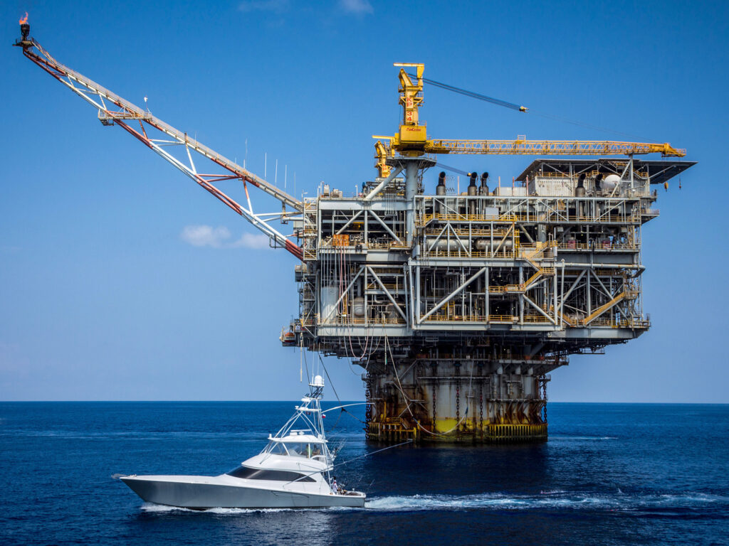 A sportfishing boat trolls for marlin in front of a Texas oil rig.