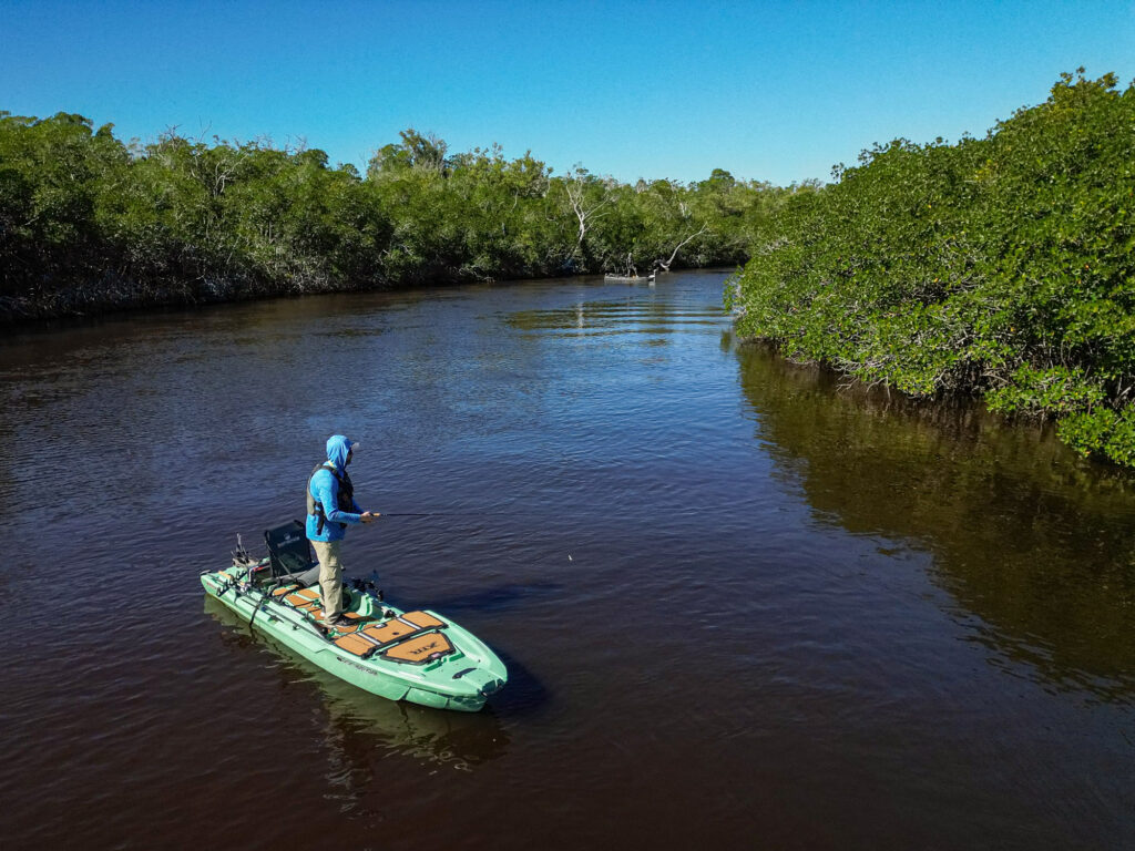 An angler fishing from a motorized kayak in the backcountry of the Florida Everglades.